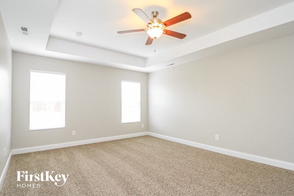 a empty living room with a ceiling fan