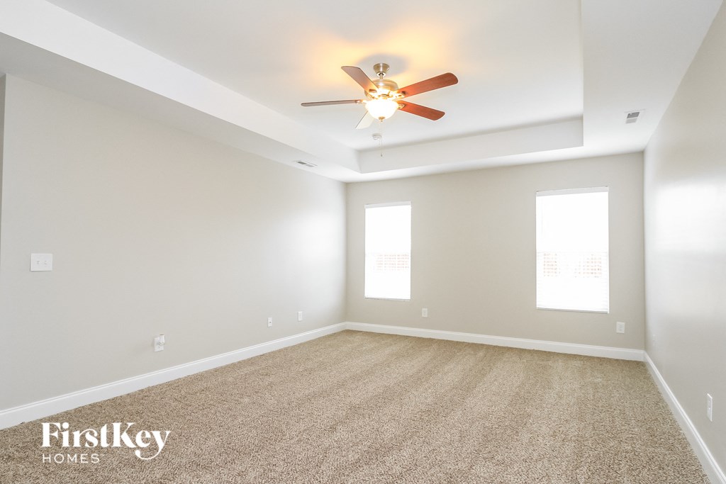 an empty living room with a ceiling fan