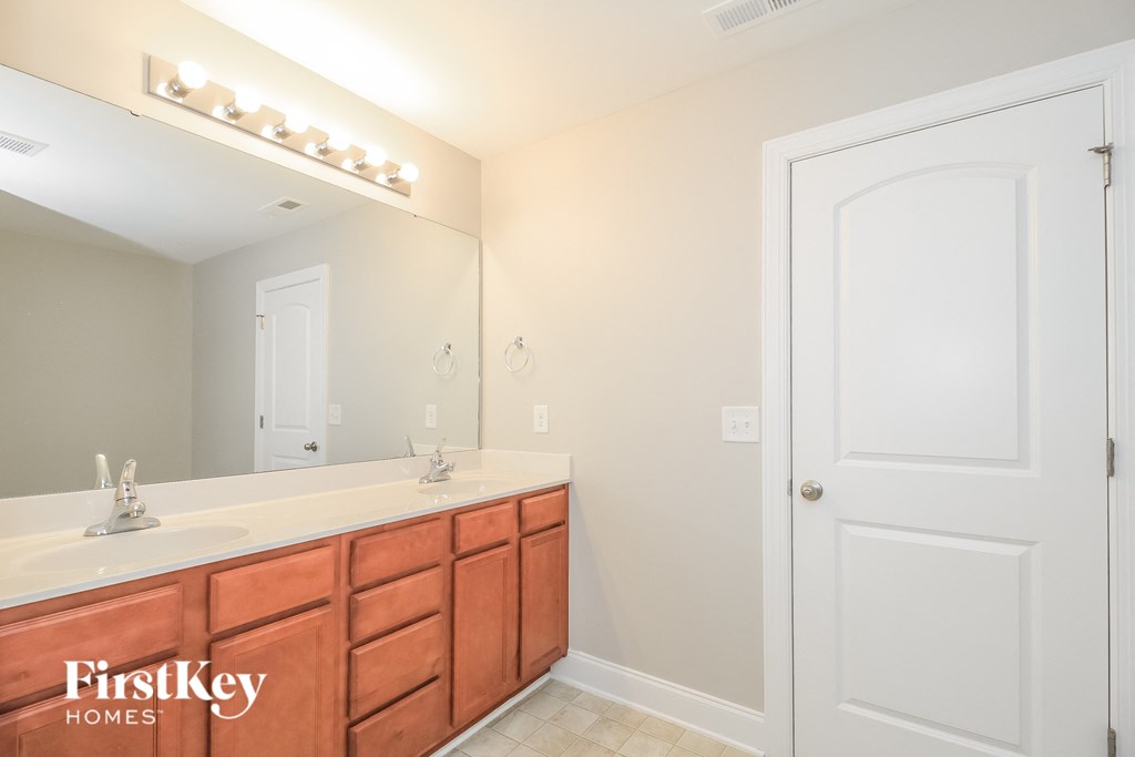 a bathroom with a sink and a mirror and a door
