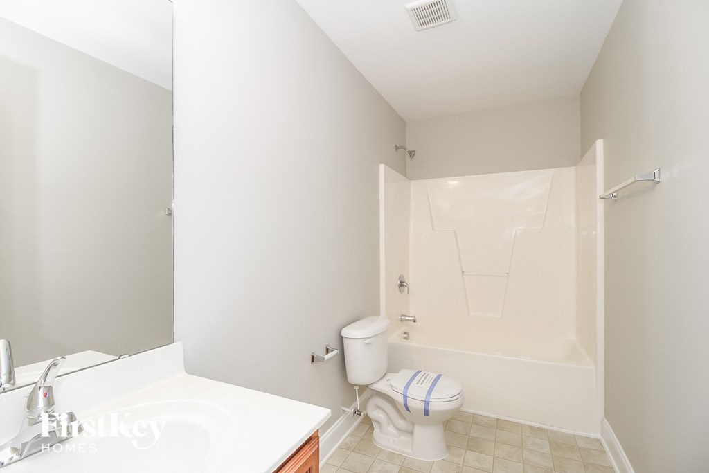a white bathroom with a white toilet and a tub and a sink