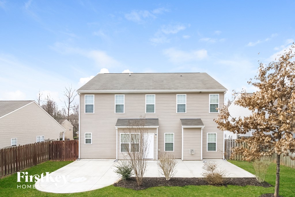 a beige house with a sidewalk in front of it