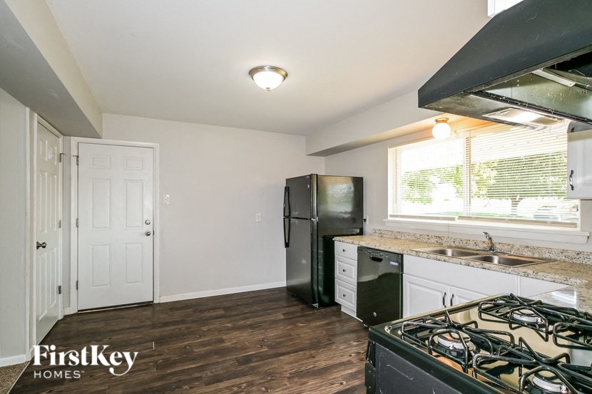 a kitchen with a stove and a refrigerator and a sink