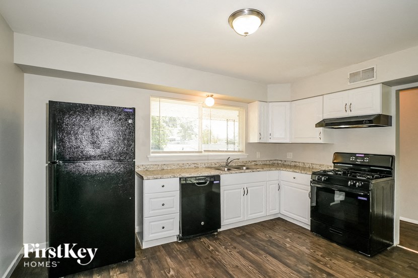 a kitchen with black appliances and white cabinets