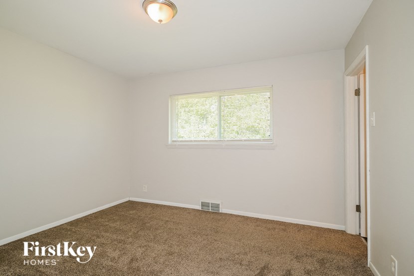 a bedroom with a carpeted floor and a window