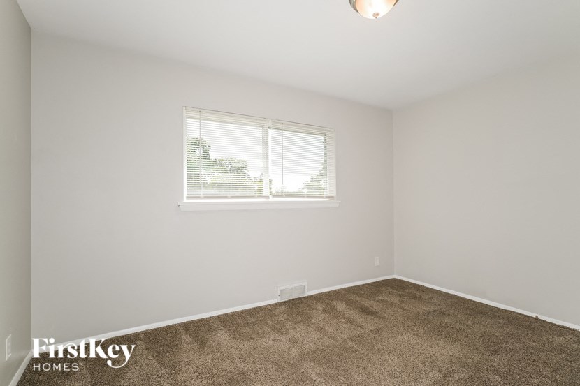 the living room of a home with carpet and a window