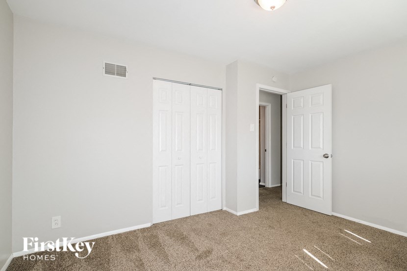 a bedroom with two closets and a door to a hallway