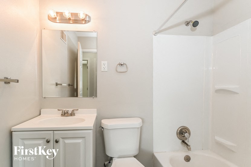 a white bathroom with a sink toilet and a mirror