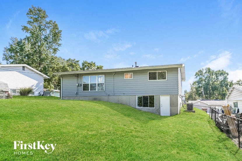 a blue house on a grassy hill with a yard