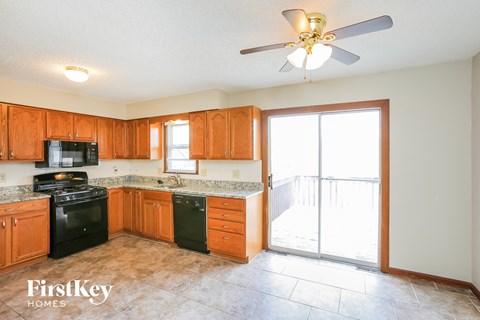 A kitchen with wooden cabinets and a black stove top oven.