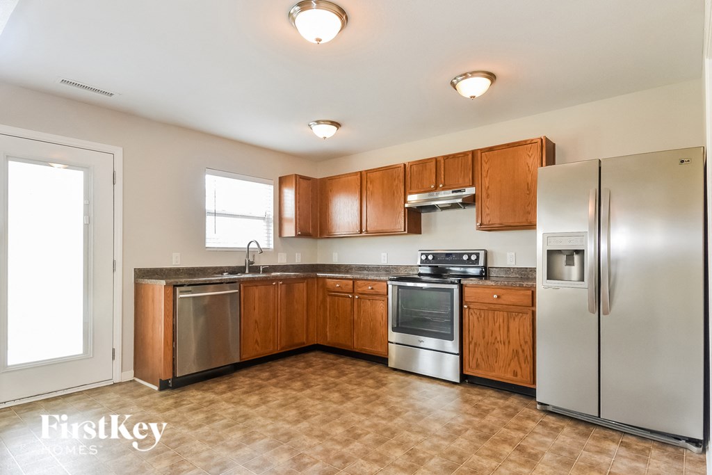 a kitchen with wooden cabinets and stainless steel appliances