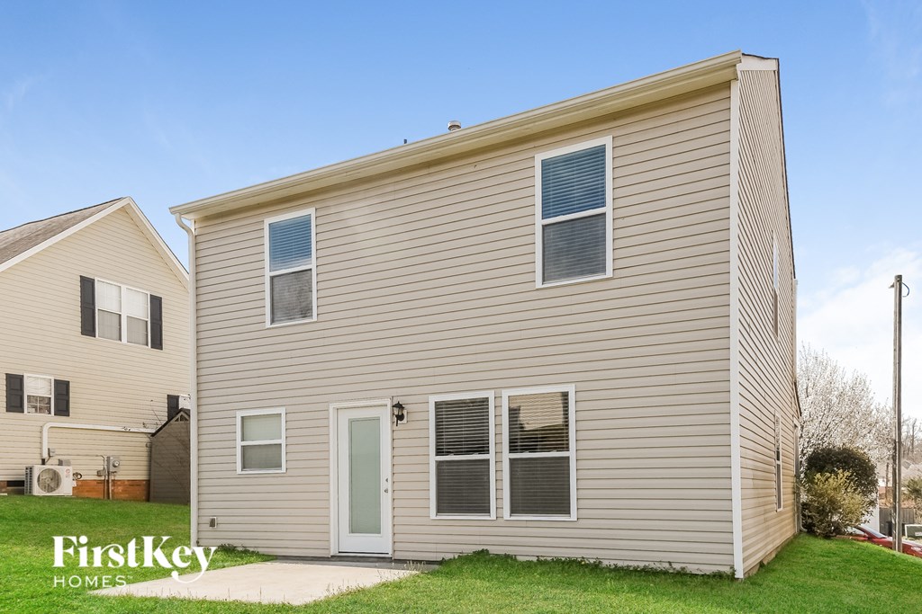 a side view of a beige house with a green lawn
