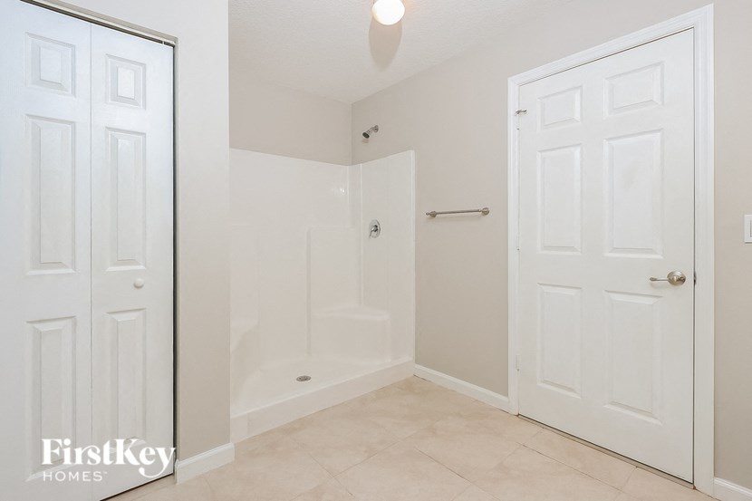 a bathroom with a shower and a white door