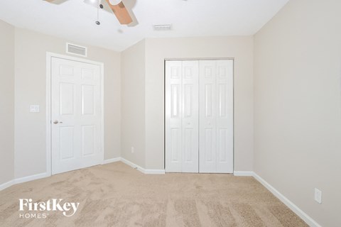 a bedroom with two white doors and a carpeted floor