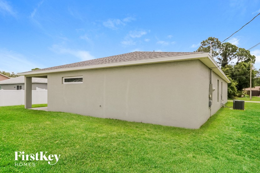 a small white house with a yard and grass