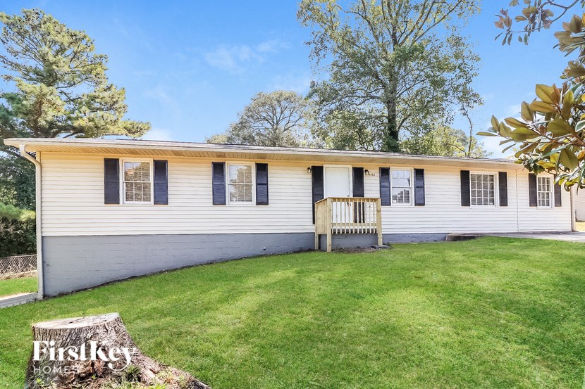 a white house with a green lawn and a porch