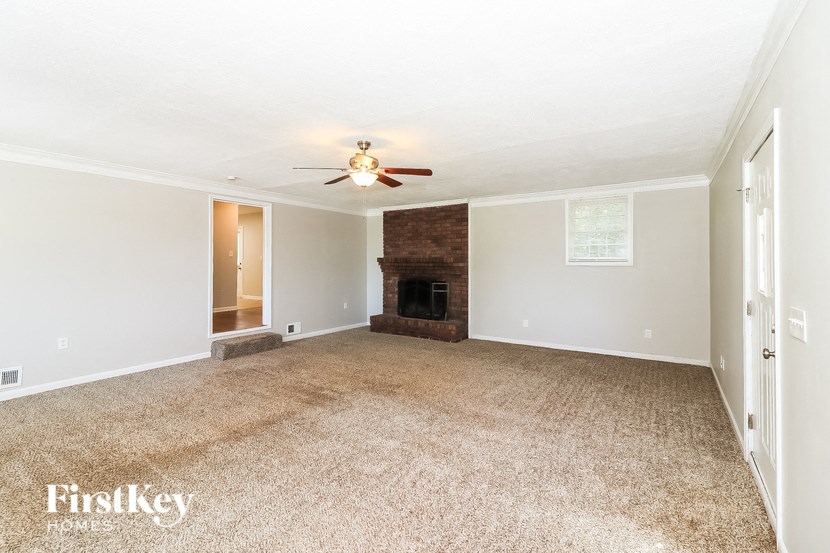 a living room with a fireplace and a ceiling fan