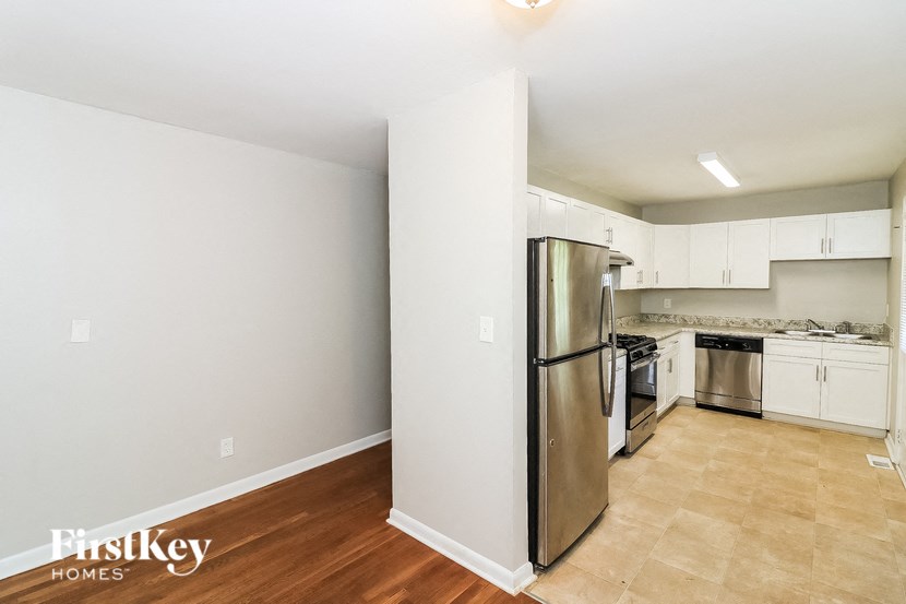 a kitchen with a stainless steel refrigerator and white cabinets