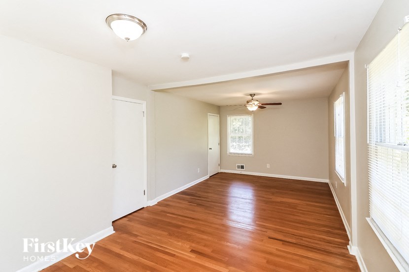 a empty living room with wood floors and a ceiling fan