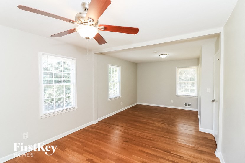 an empty room with a ceiling fan and wood floors