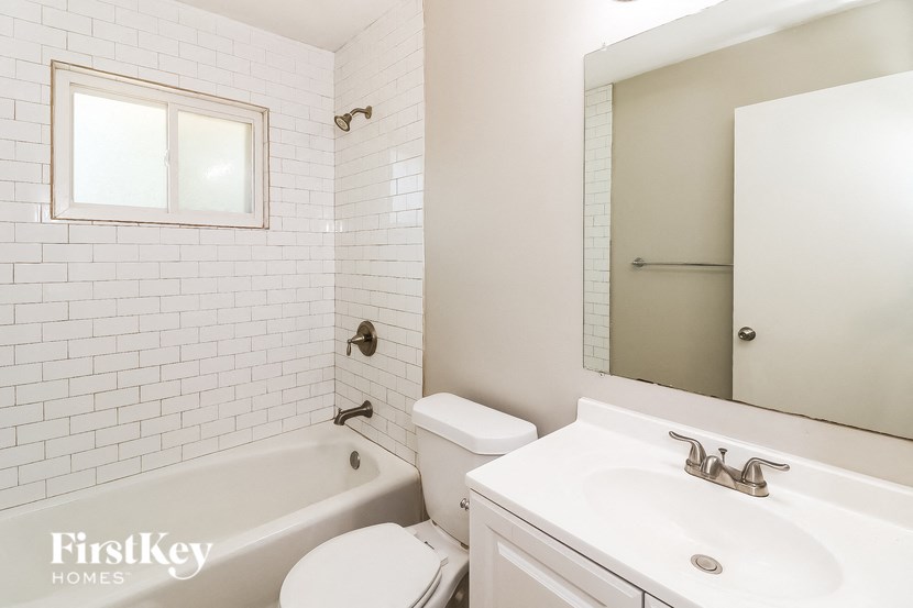 a white bathroom with a sink toilet and bath tub