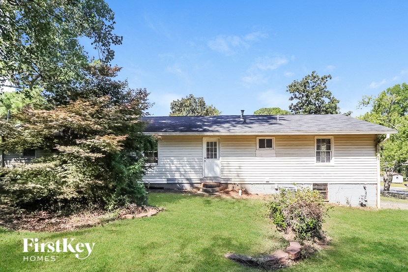 a white house with a yard and a blue roof