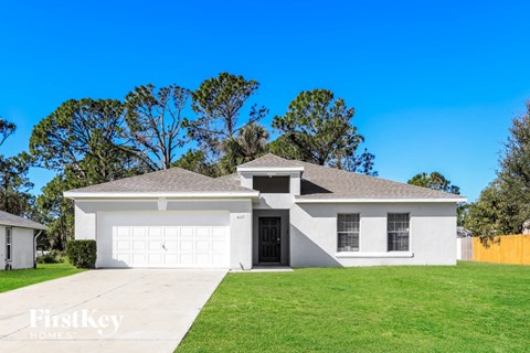 a white house with a lawn and a garage door