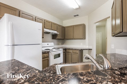 a kitchen with white appliances and granite counter tops