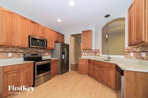 A kitchen with wooden cabinets and a brick backsplash.