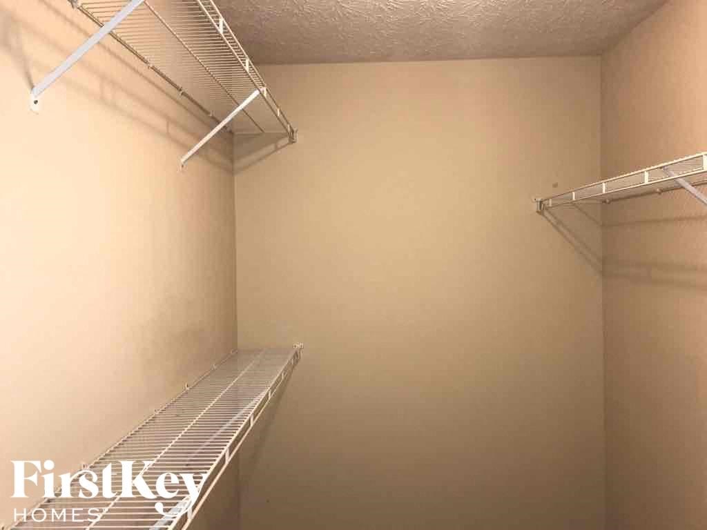 a walk in closet with empty shelves in it