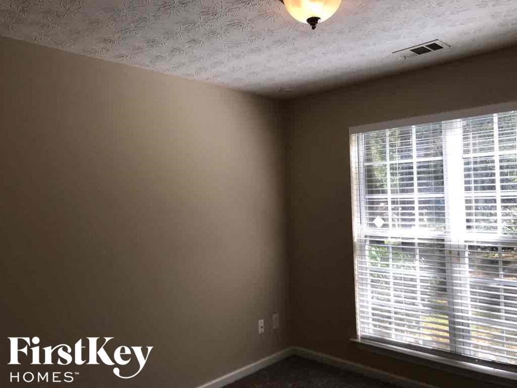 the corner of a room with a window and a light on the ceiling