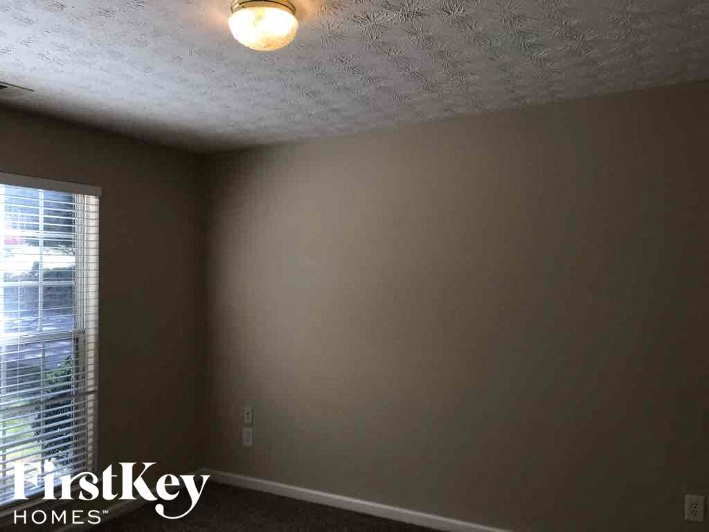 a bedroom with a white ceiling and a window