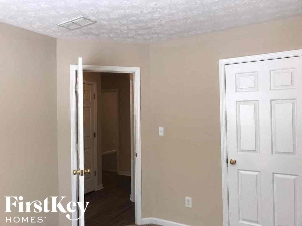 an empty room with a white door and a white closet