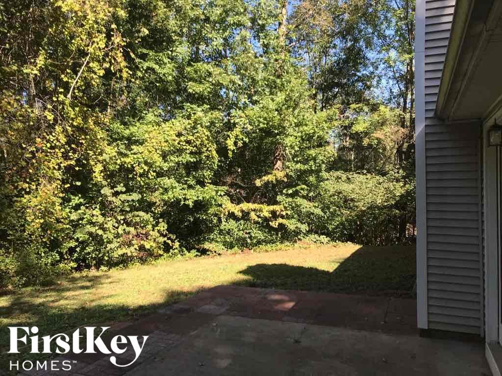 the backyard of a house with grass and trees