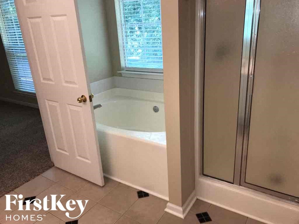 a small bathroom with a bath tub and a closet