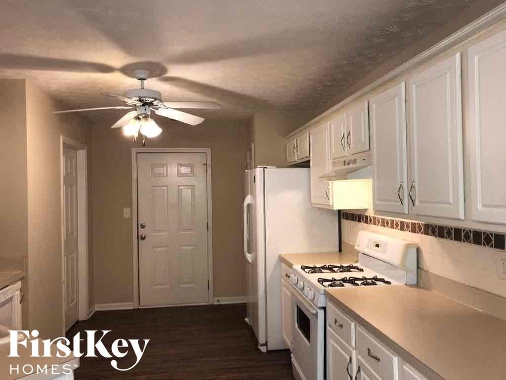 a kitchen with white cabinets and a ceiling fan