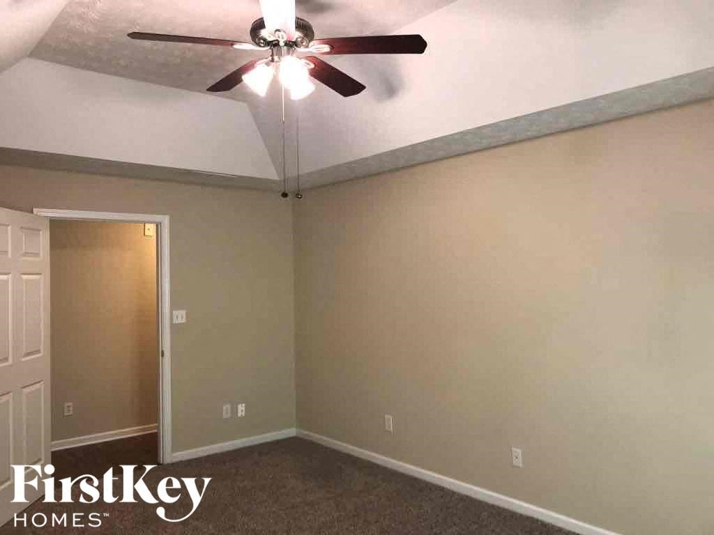 a empty room with a ceiling fan and a door to a closet