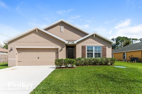 a beige house with a lawn in front of it