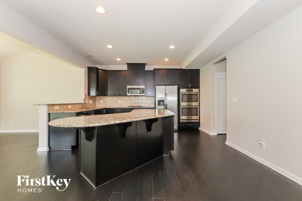 a large kitchen with black cabinets and granite counter tops