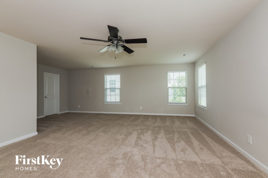 a living room with carpet and a ceiling fan