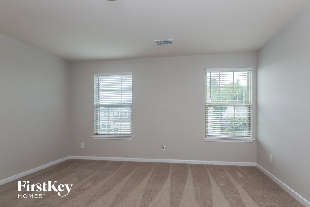 a living room with two windows and a wooden floor