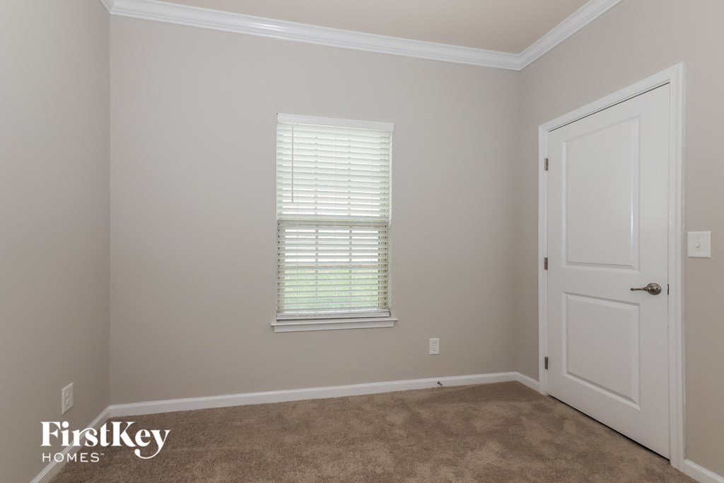 a empty room with a white door and a window