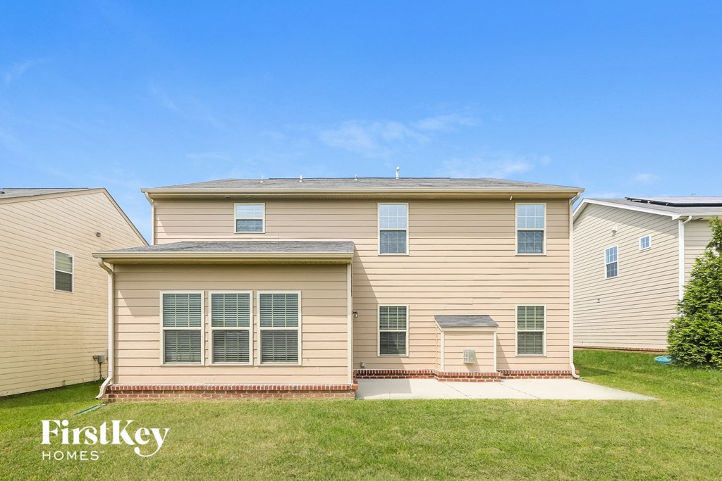 a yellow house with a green lawn and a blue sky
