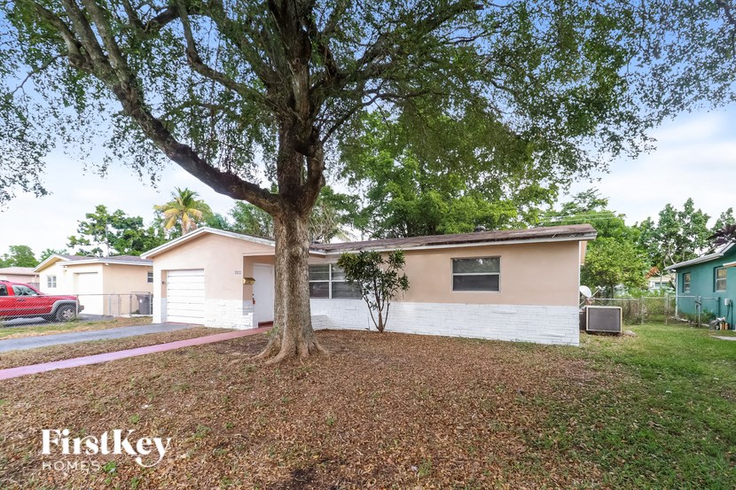 a small white house with a tree in the yard