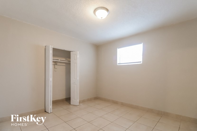 an empty room with a closet and a white door