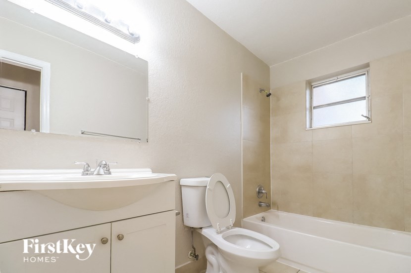 a bathroom with a toilet and a sink and a bath tub