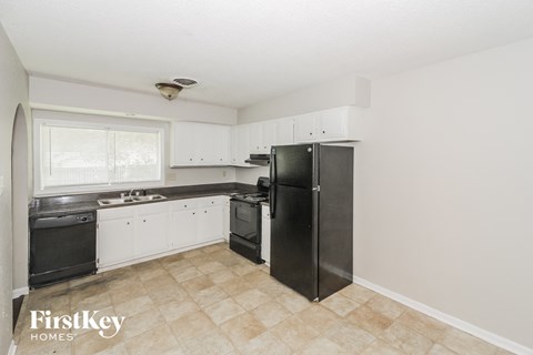 a kitchen with black appliances and white cabinets