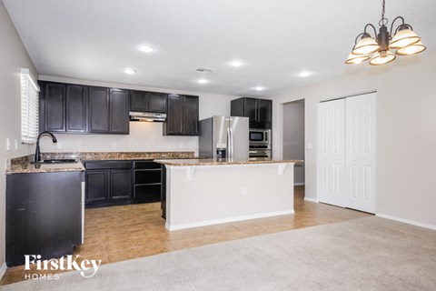 A kitchen with black cabinets and a white island.