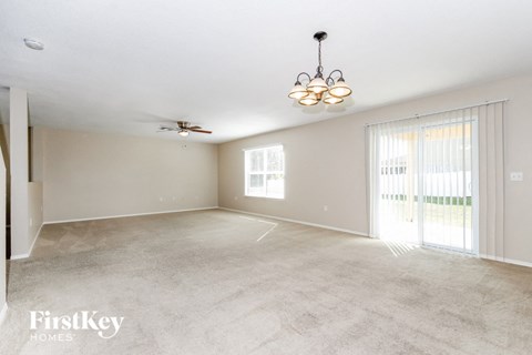A spacious room with a chandelier and a ceiling fan.