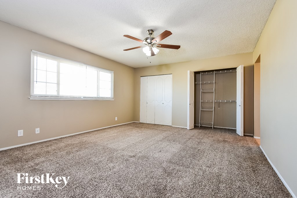 A spacious room with a ceiling fan and a window.