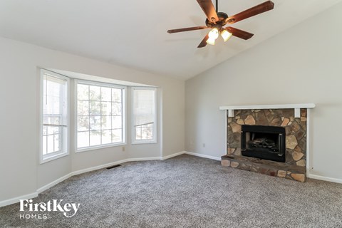 A room with a fireplace and a ceiling fan.
